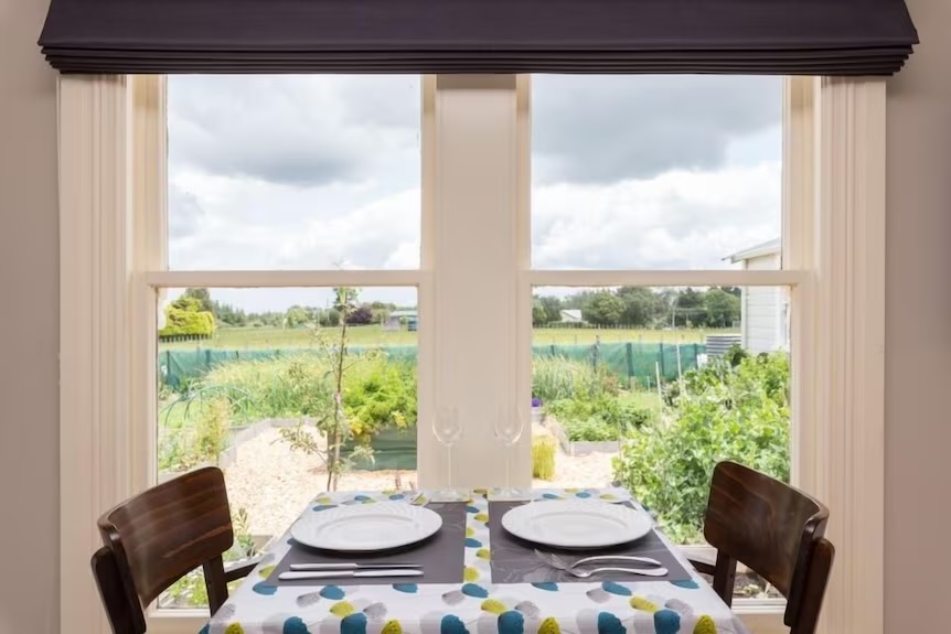 Apartment dining area with a window looking out to paddocks