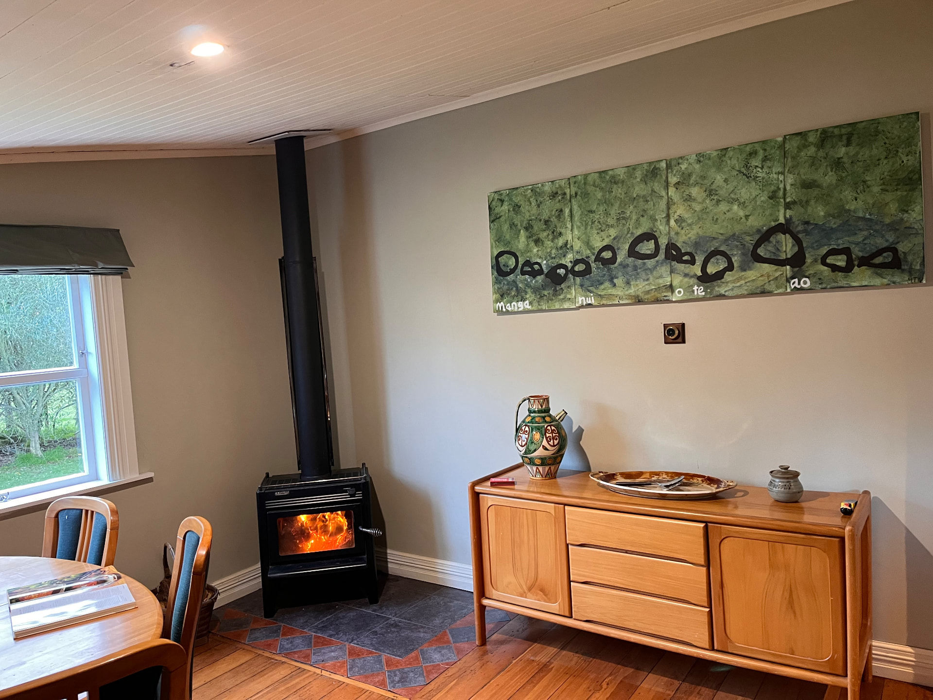 Dining room with a freestanding black wood burner and timber floors