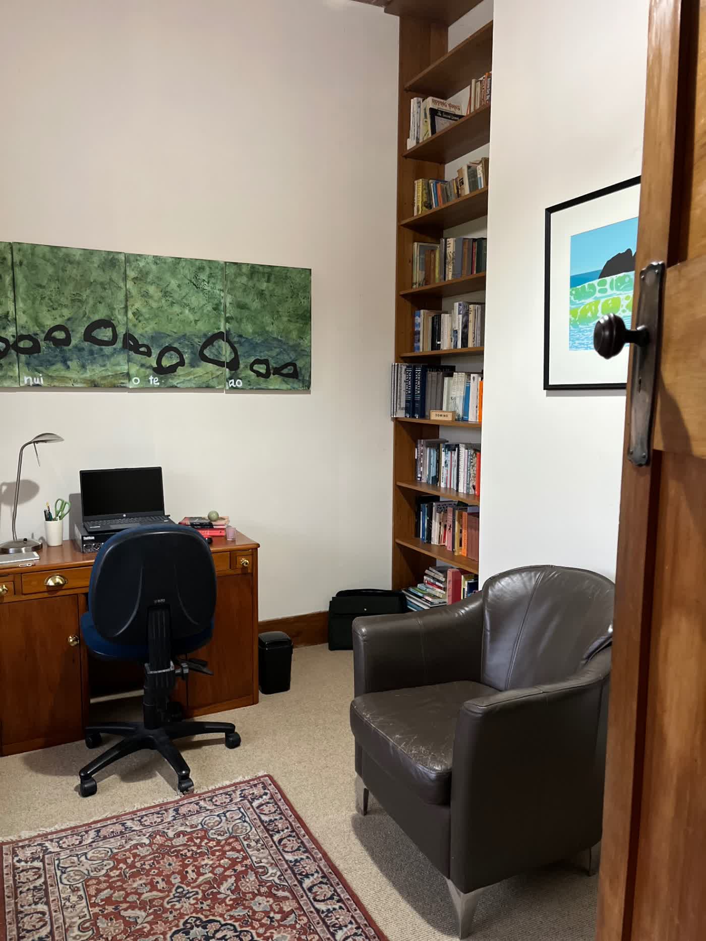 Study with a desk, monitor and office chair by the window