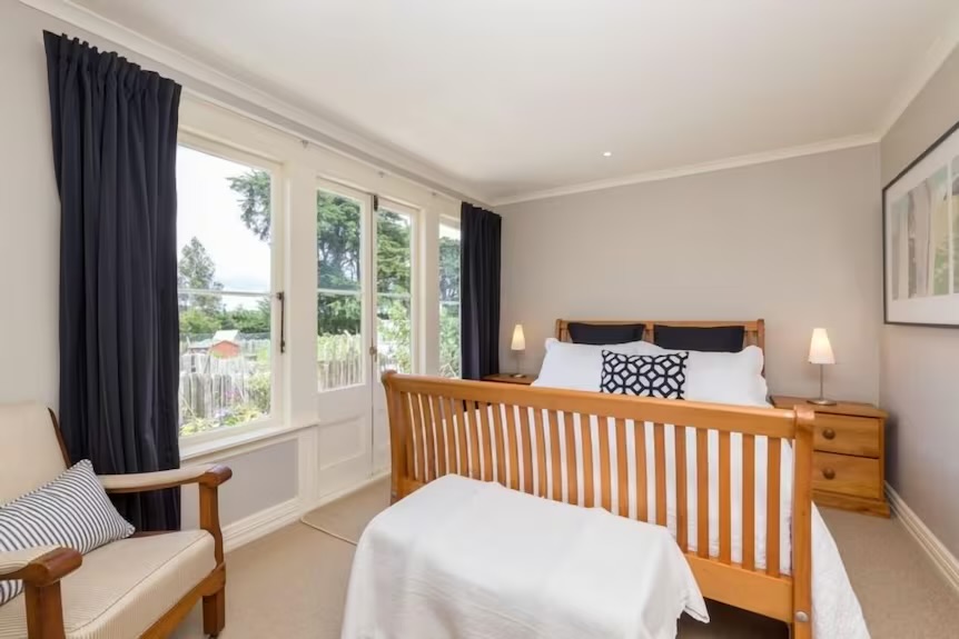 Apartment bedroom with wooden bed and garden view