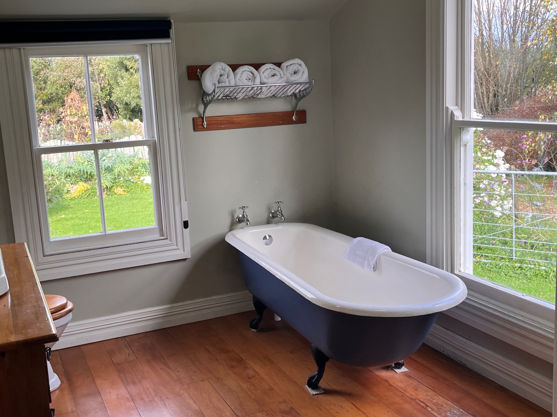 Clawfoot bathtub between two windows