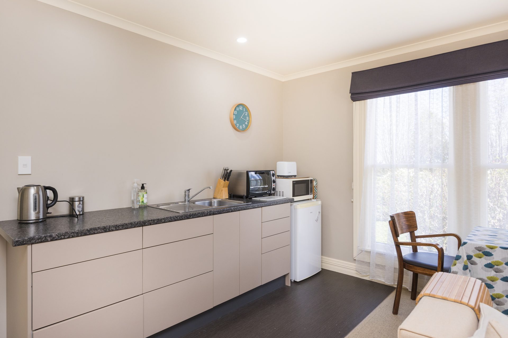 Kitchenette of the self-contained apartment with a bench, sink and dining table