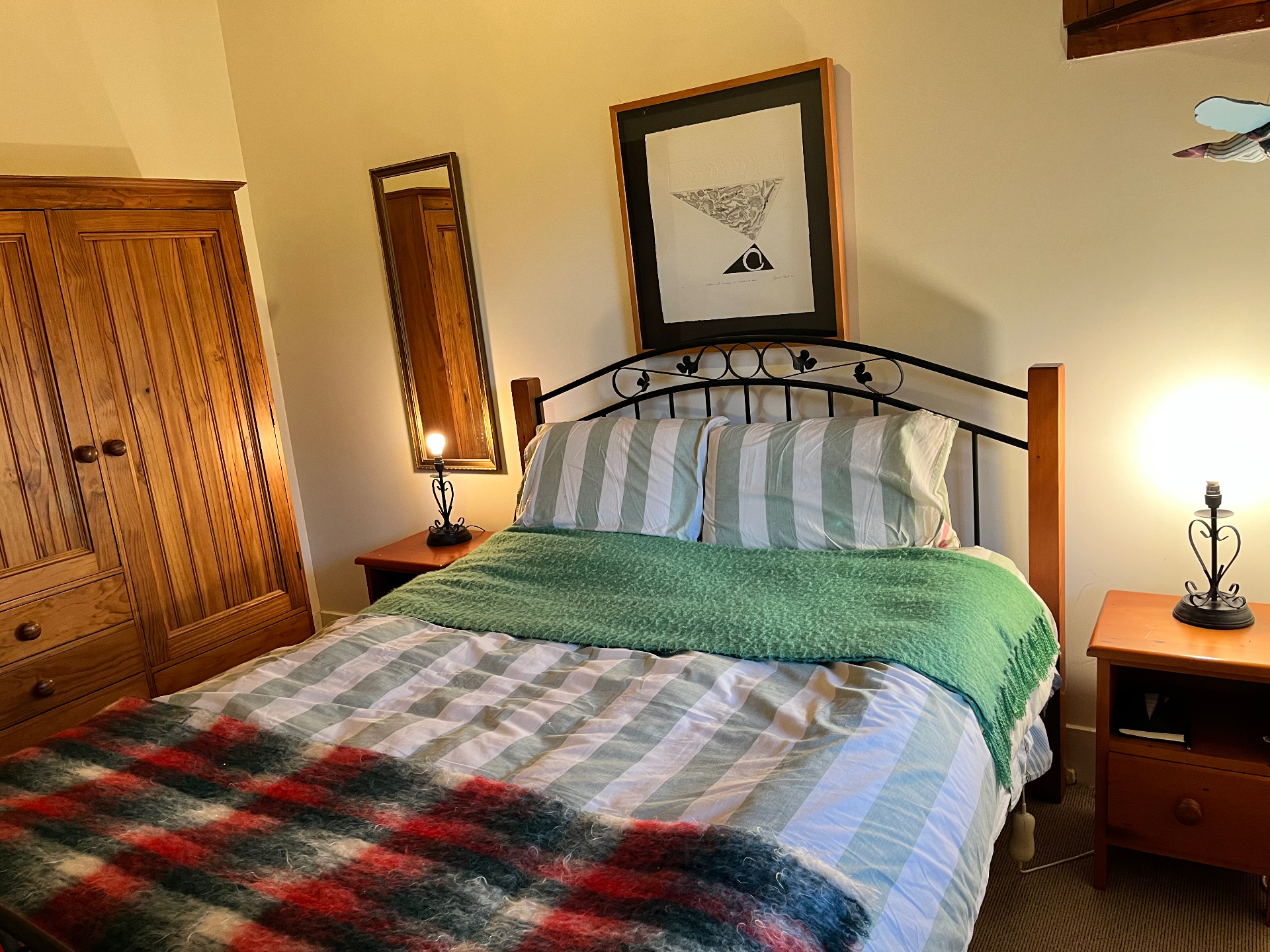 Second bedroom with green mohair throw and bedside lamps